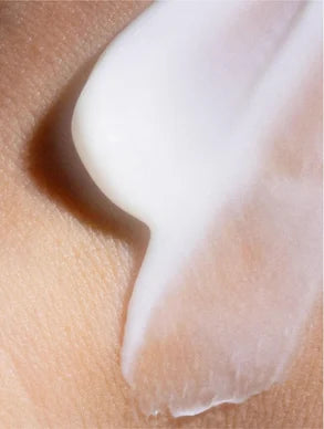 Close-up of a white cream being applied to skin