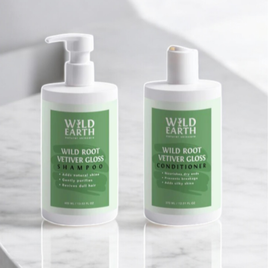 Two bottles of Wild Earth Wild Root Vetiver Gloss shampoo and conditioner on a white background